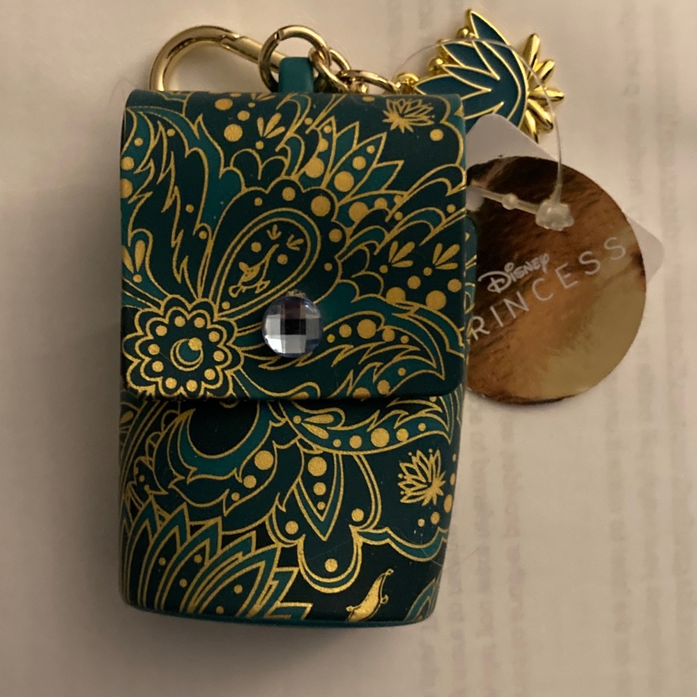 Disney Green and Gold Floral Jasmine keychain that holds antibacterial gel